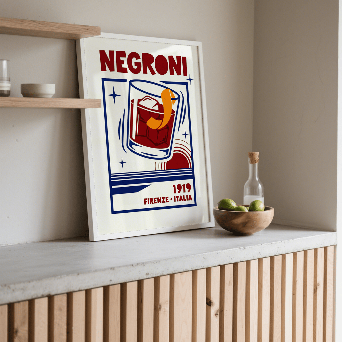 Negroni Cocktail Print leaning on a shelf near a wooden bowl with limes and glass bottle