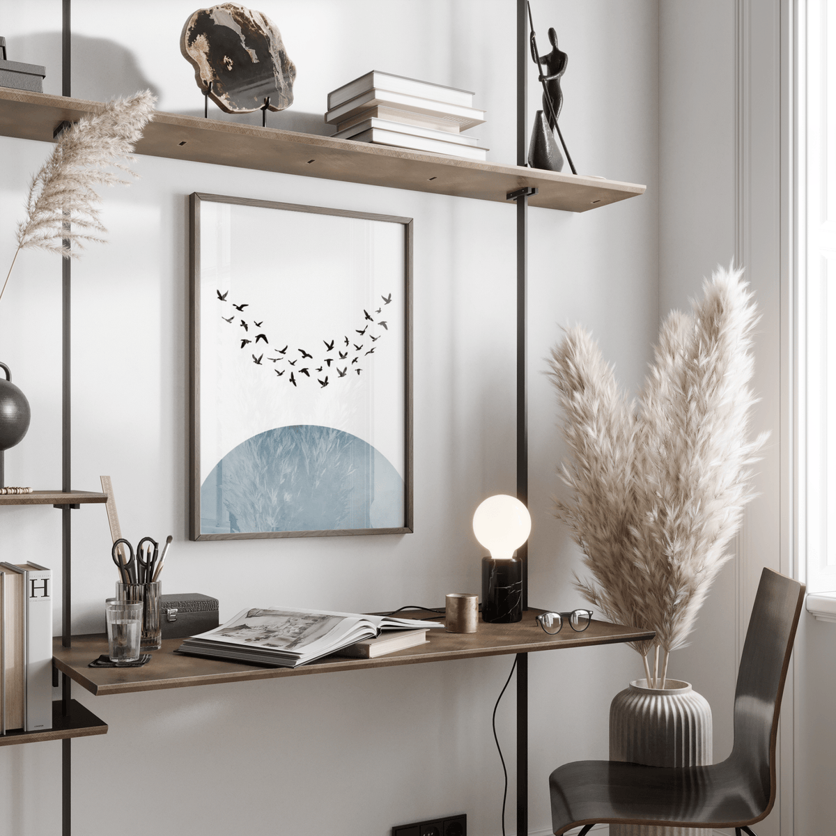 Minimal wall decor print of flying birds silhouette with blue semi circle on a desk near pampas grass