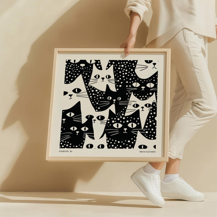 Framed cat art black and white print of abstract minimalist cats held by a person in white clothes