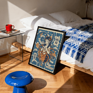 Print leaning on floor of Jorogumo Art showing spider woman in blue and orange tones with sunlight shadows in bedroom