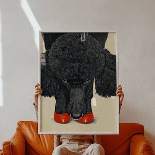 Framed Poodle wall art showing a black poodle with red shoes held above an orange sofa