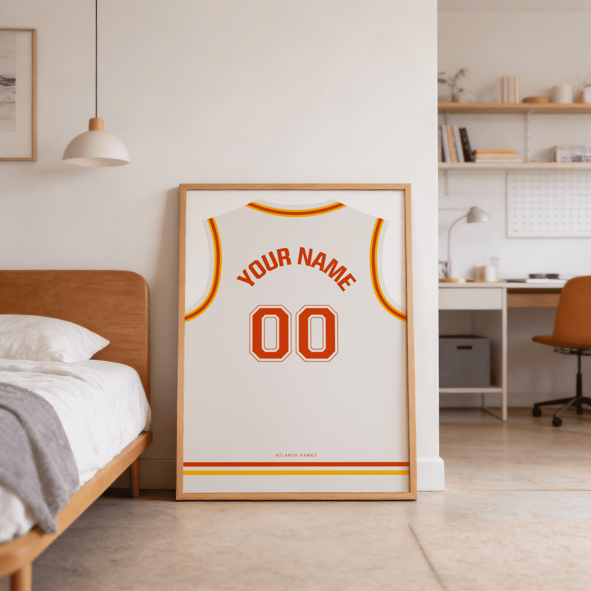 Basketball Jersey Poster in White with Red and Yellow Trim leaning on bedroom floor near wooden bed