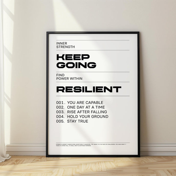 Keep Going Poster print leaning on floor with black frame and sunlight on cream wall