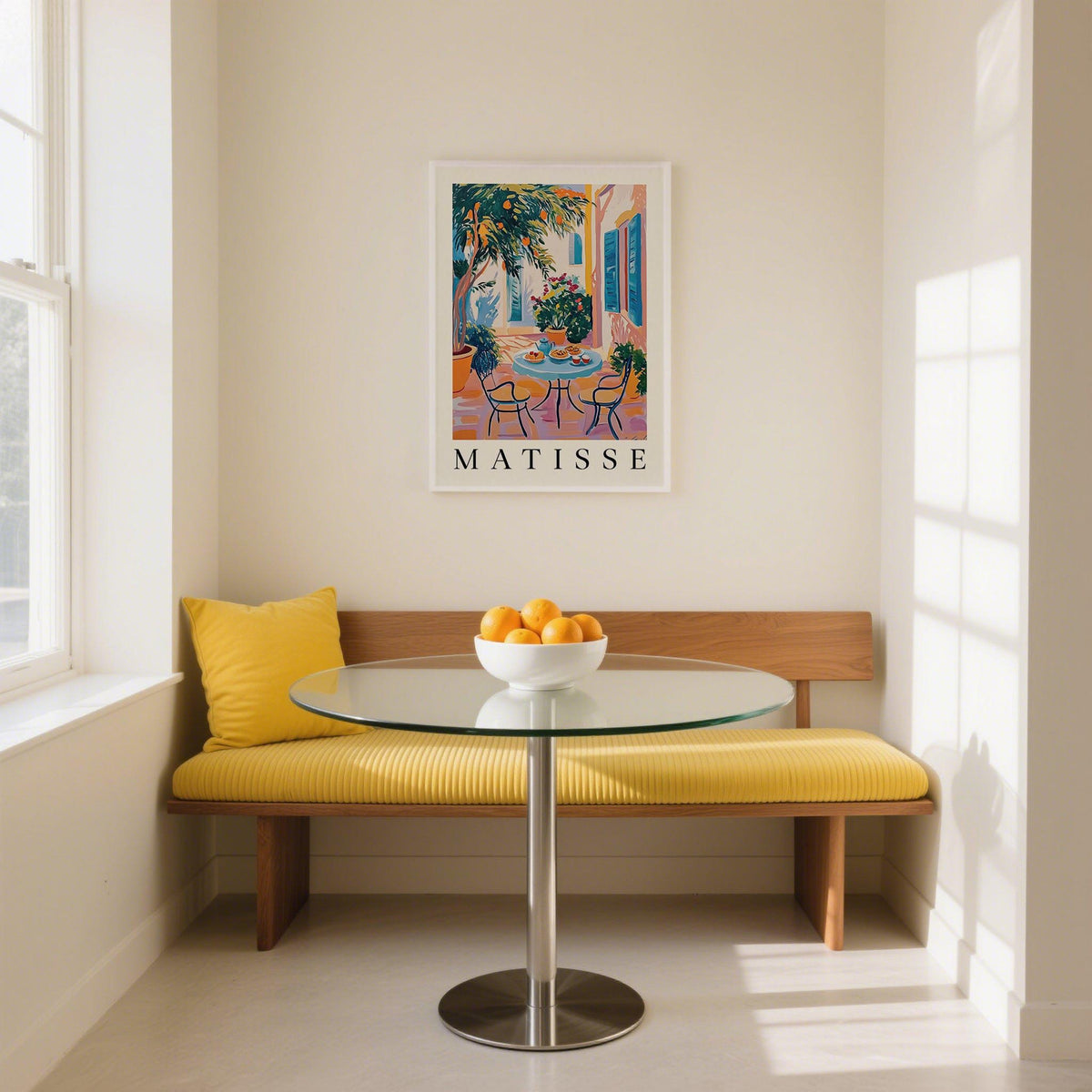 Wall Art Mediterranean print of a citrus tree patio scene above a yellow cushioned bench in a bright dining nook