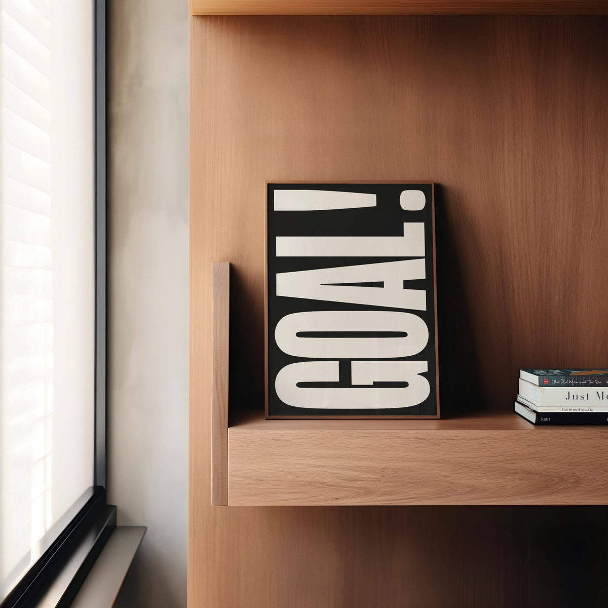Goal poster leaning on a wooden shelf with black and white minimalist typography