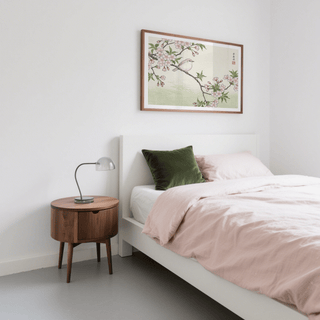 Bird Cherry Blossom Art Print framed on a bedroom wall above a white bed with pale pink bedding and green cushion
