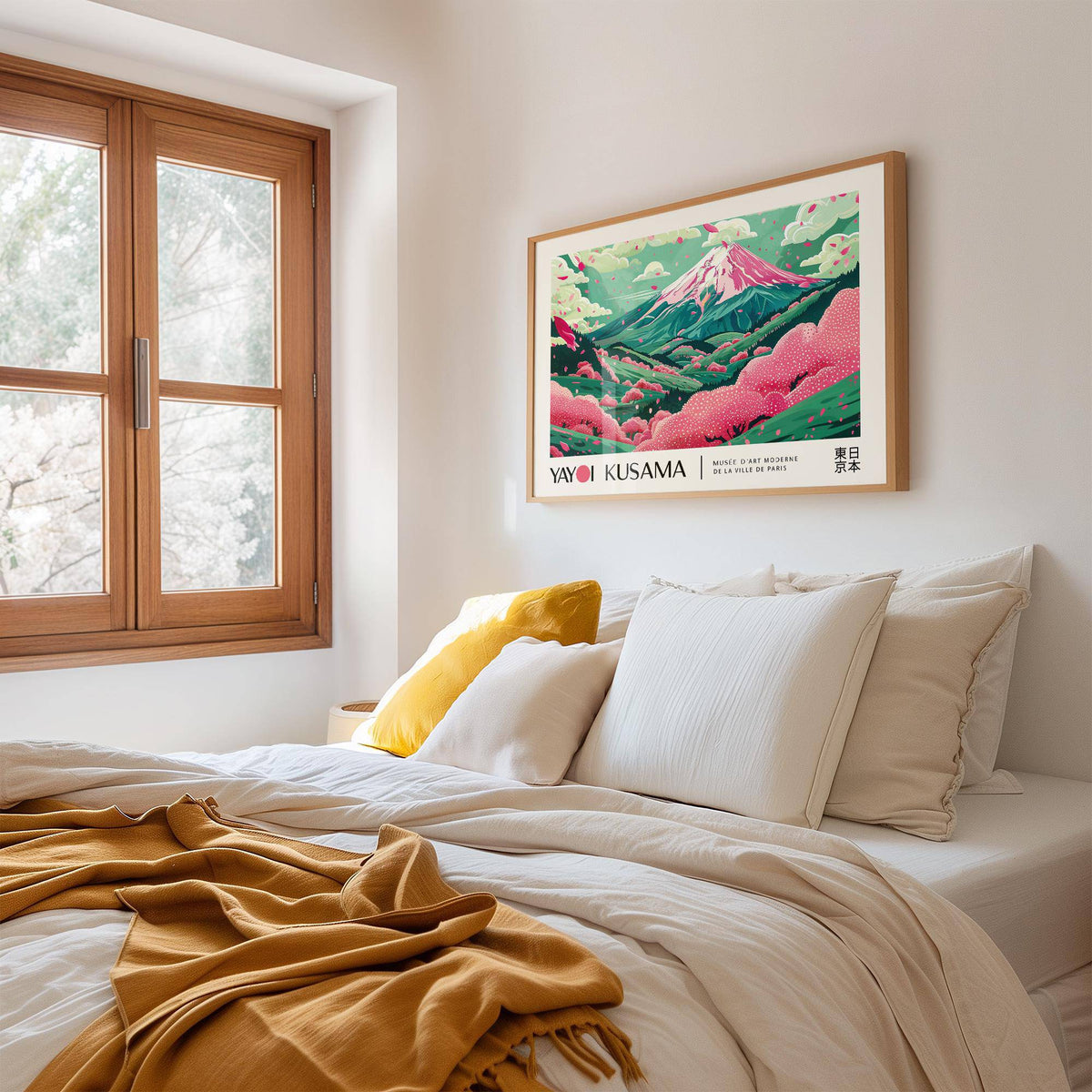 Cherry Blossom Art framed print with pink and green hills above a bed with yellow and white cushions