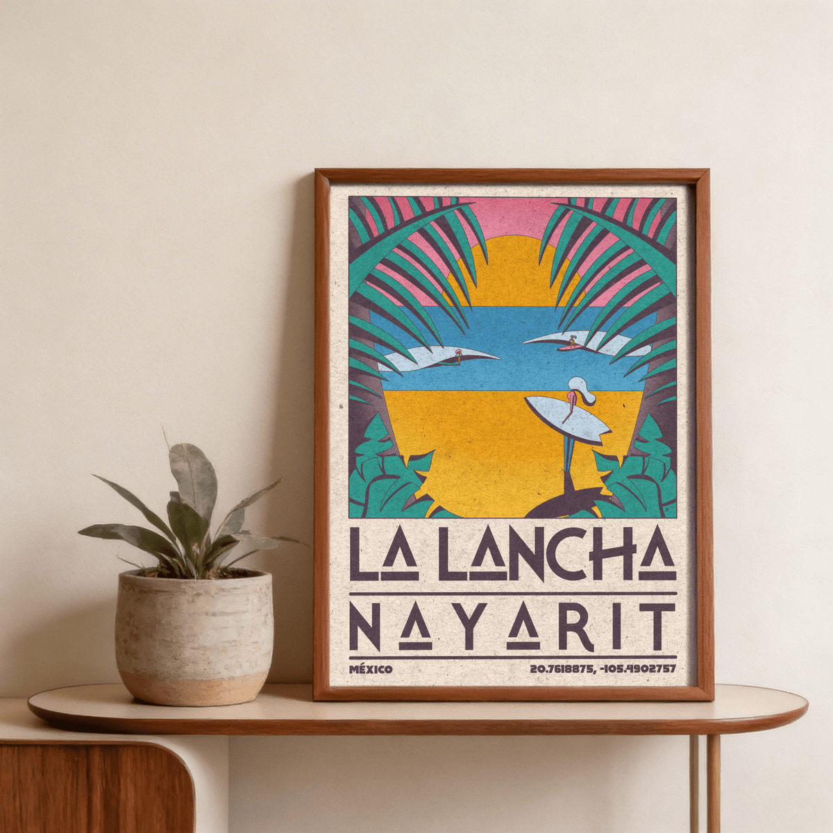 Framed Surfer Beach Art Print with retro style and bold sunset colours beside a small potted plant