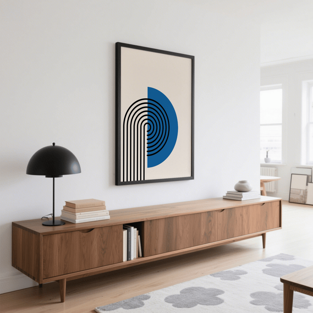 Abstract Arch Print with black and blue minimalist arch above a wooden sideboard and lamp in a living room