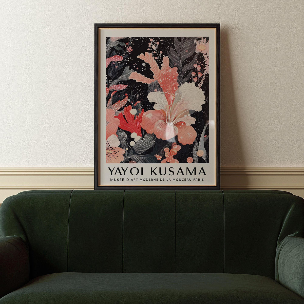 Black and Pink wall art of a pink hibiscus flower with dark leaves above a dark green sofa