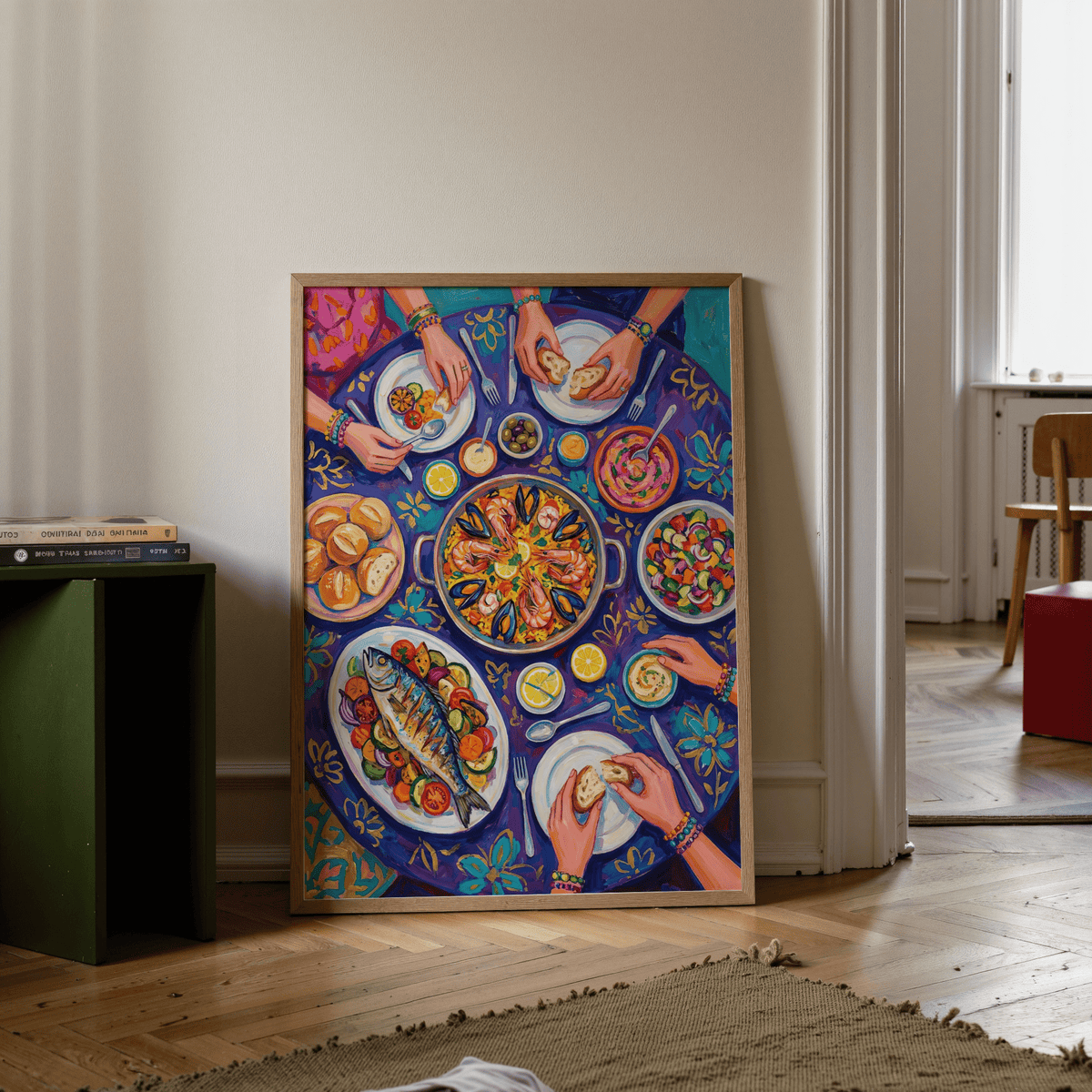 Food art print leaning on floor against wall showing Mediterranean feast with blue and purple tones beside a green side table