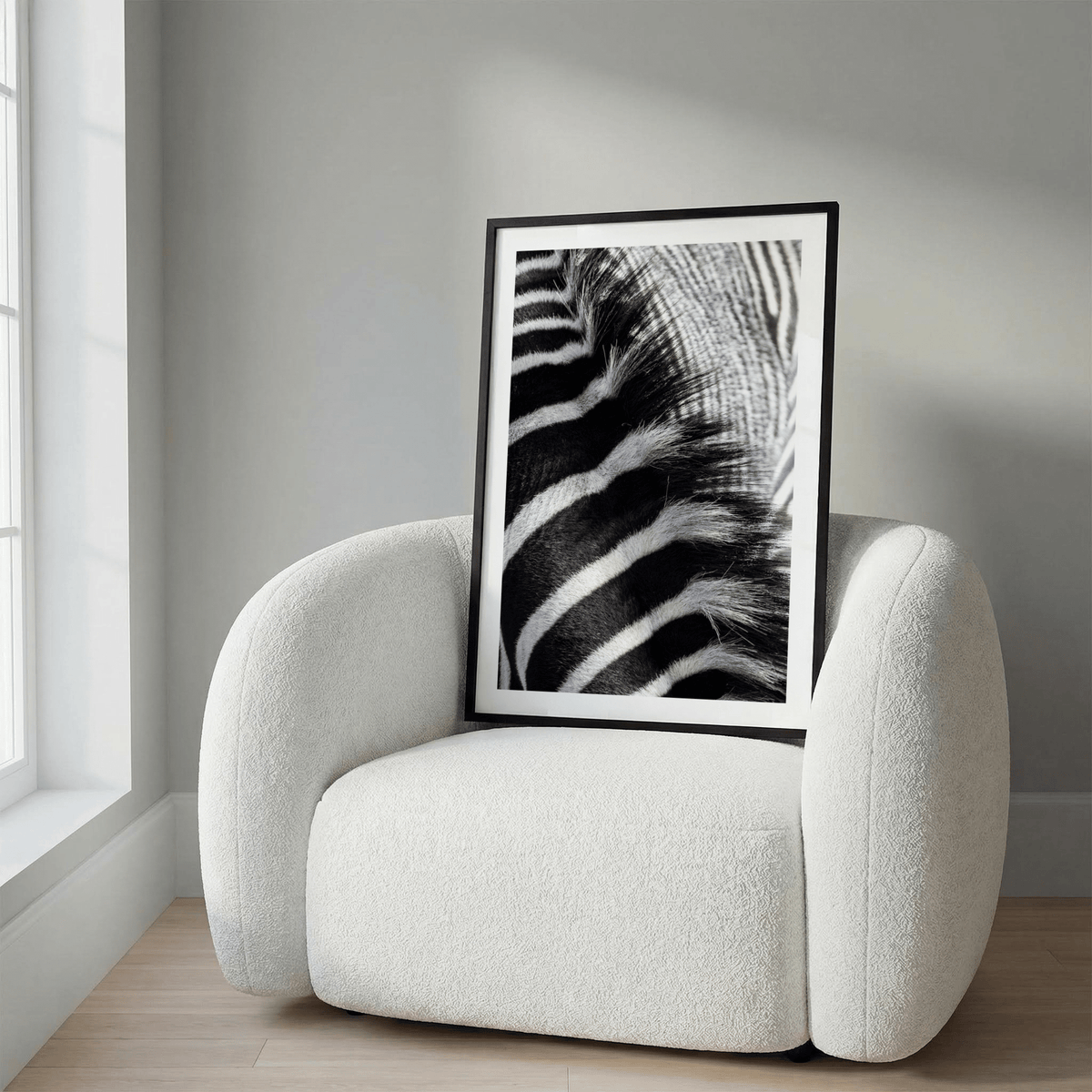 Zebra Stripe Art Print close-up of black and white zebra stripes framed in black resting on a white armchair