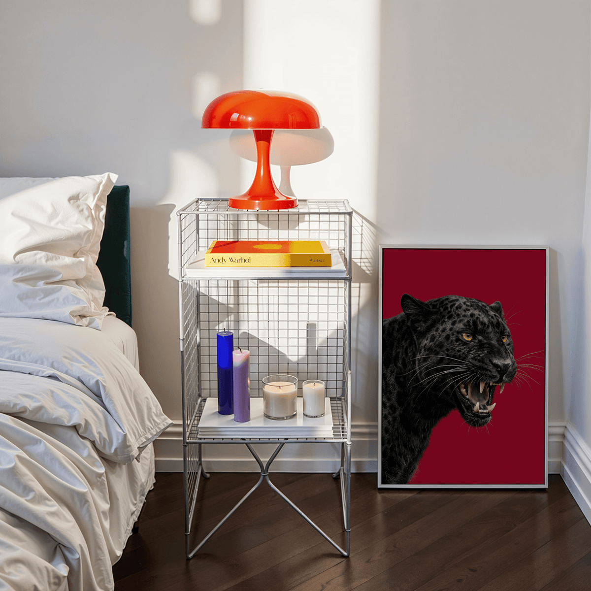 Print leaning on floor with black panther head on red background beside modern bedside table and bed