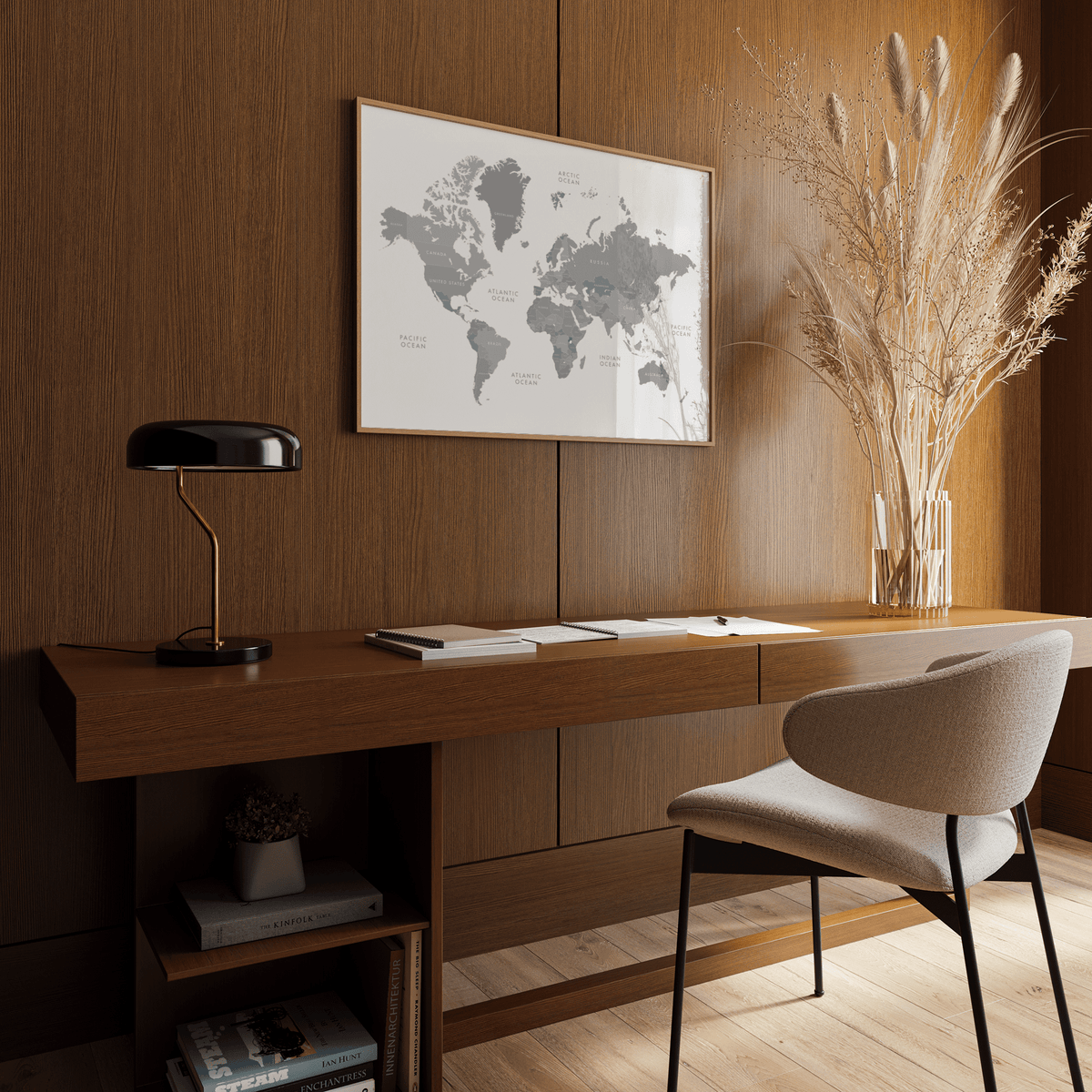 World Map Art print hanging above a wooden desk with a black lamp and a vase with dried grasses