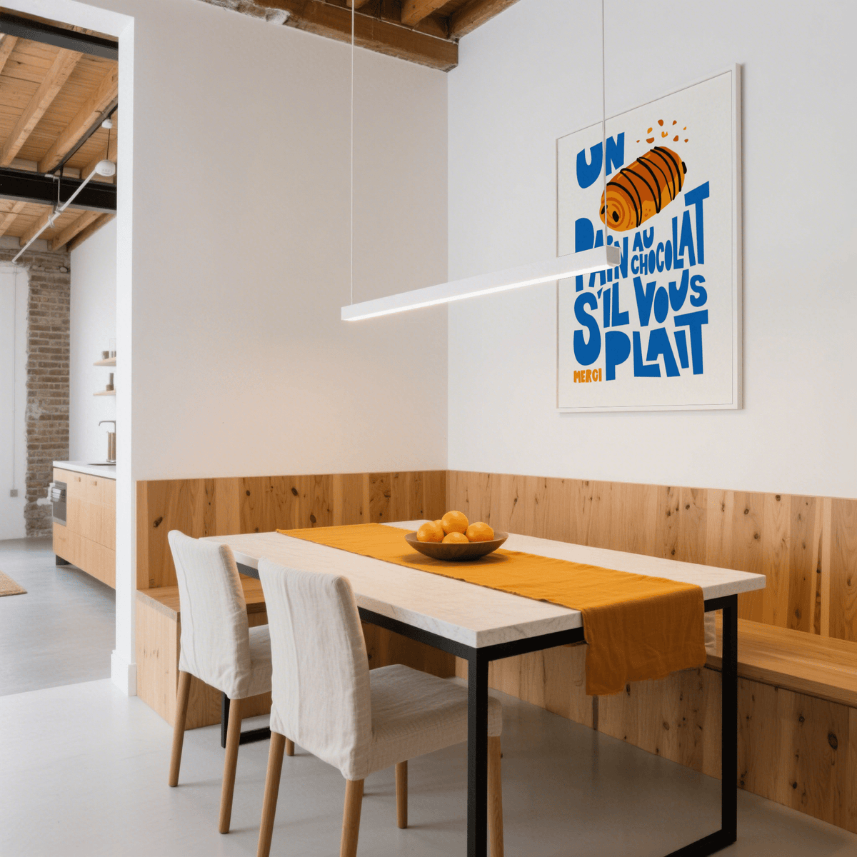 Pain Au Chocolat Print on a wall above a dining table with orange runner and bowl