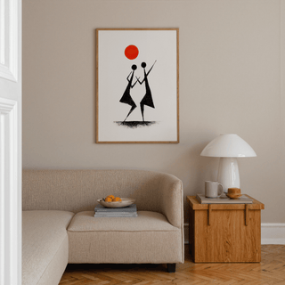 Warli Folk Art Print of tribal dancers in black with an orange sun above a beige sofa in a living room