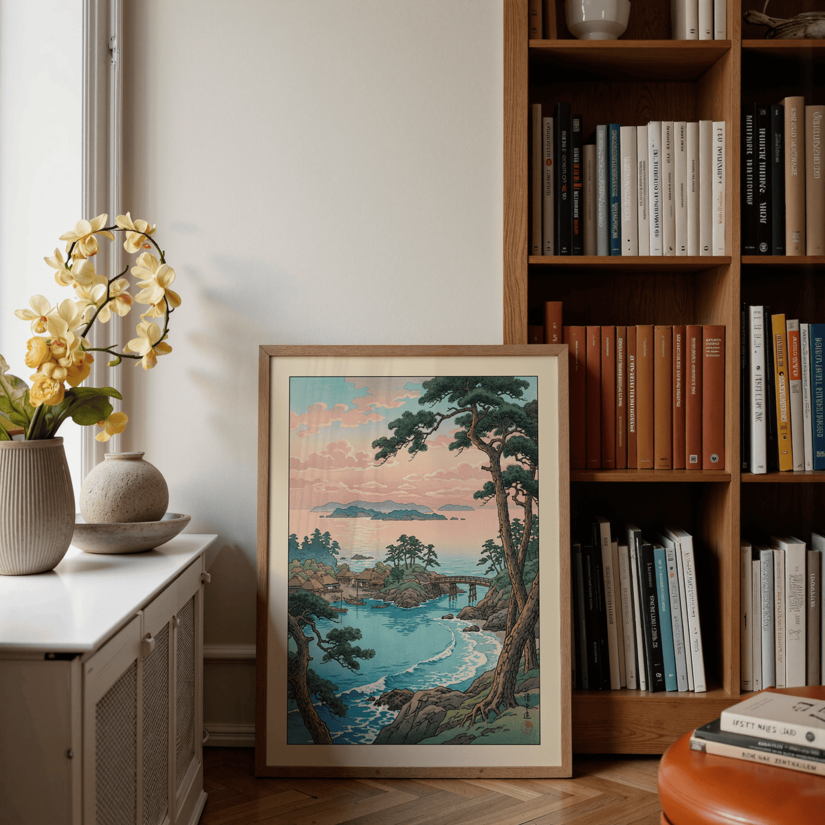 Hasui Kawase Sea Landscape Print leaning against a wall by a bookshelf with beige and brown books
