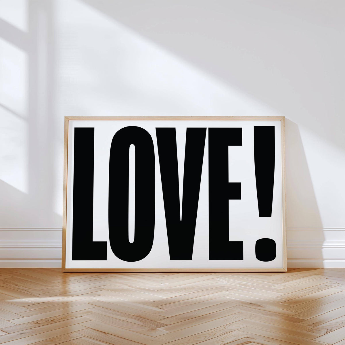 Large Motivational Posters leaning print with LOVE typography in black and white on a parquet floor