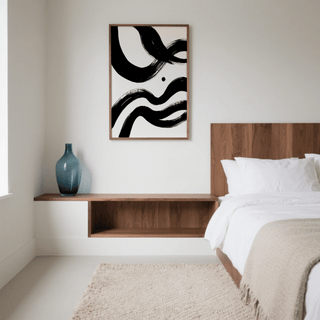 Black and white paintings abstract with black ink waves above wood shelf with a blue vase in a bedroom