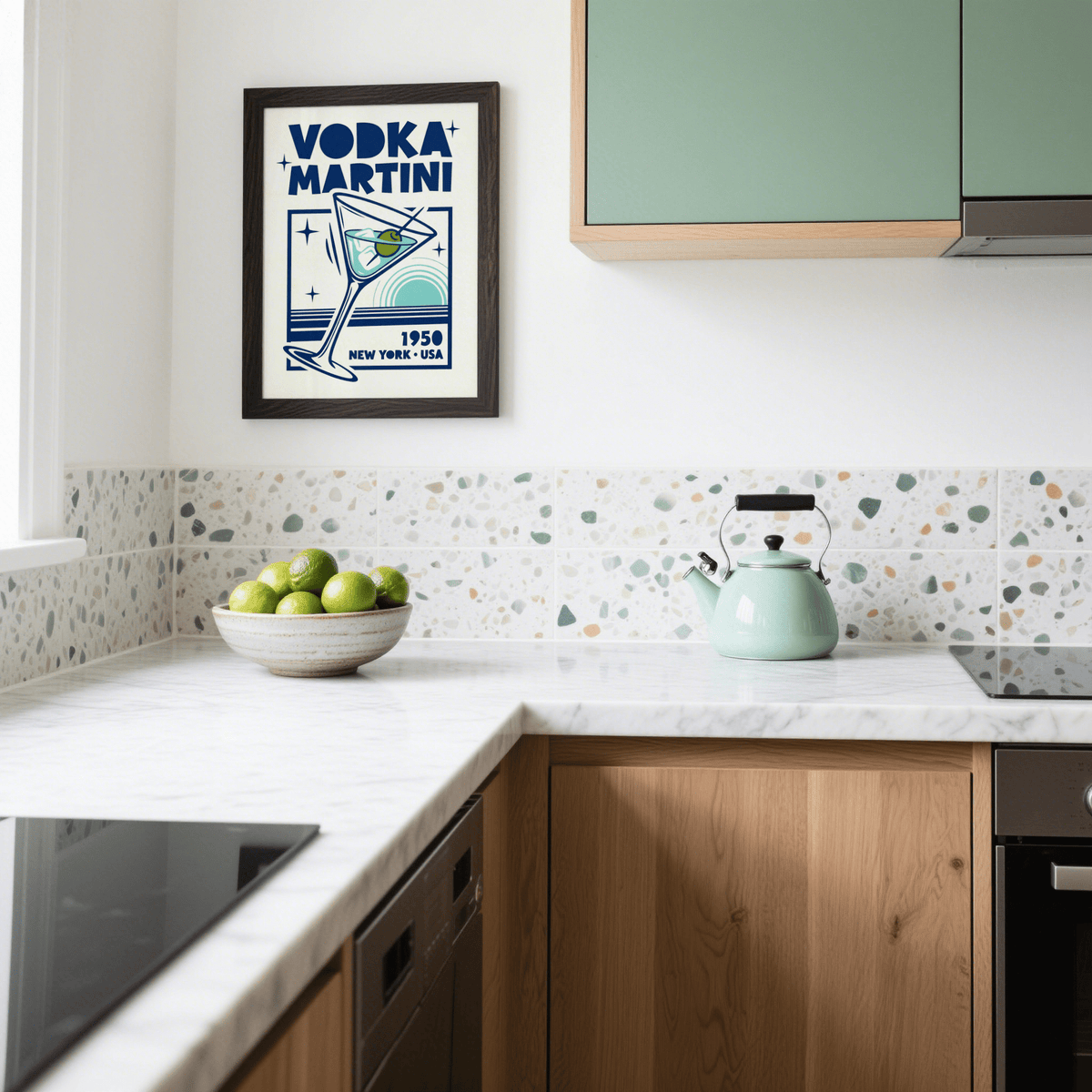 Print on a wall in a kitchen of a vodka martini glass illustration with blue and green details above a bowl of green apples