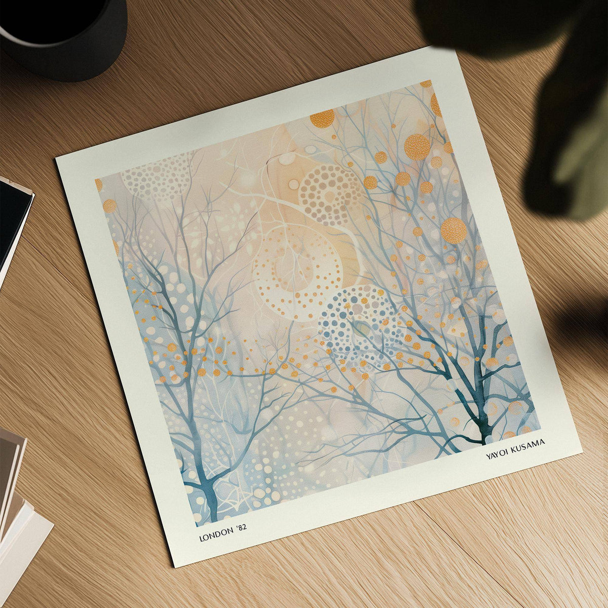 Detail close-up of minimalist poster art showing abstract branches with orange and blue dots on a wooden surface