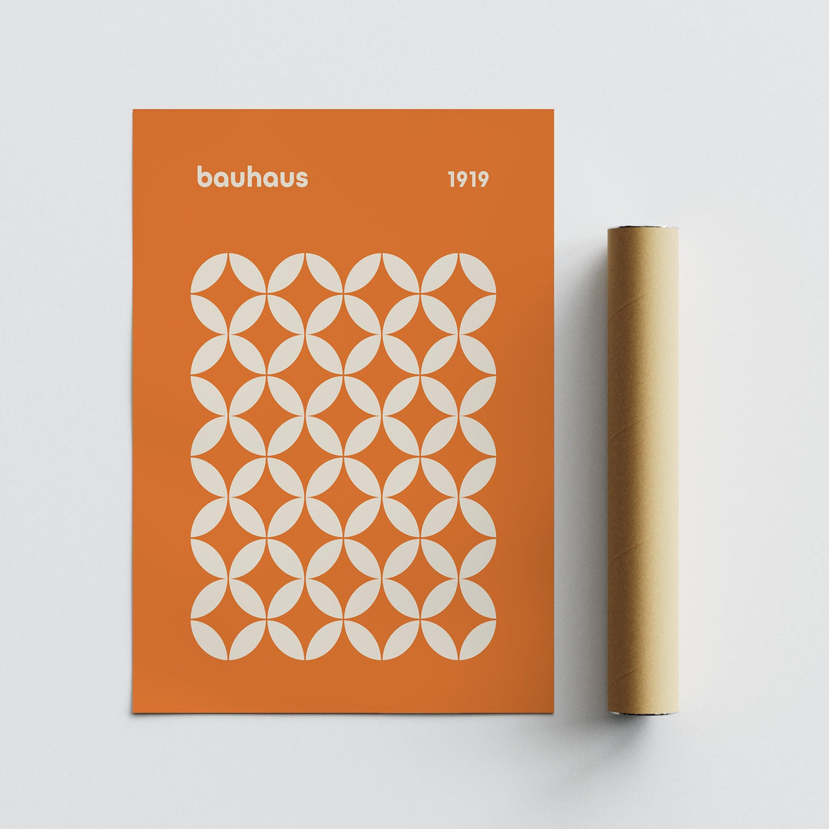 Orange Poster with bauhaus style circle grid pattern in white next to a brown packaging tube