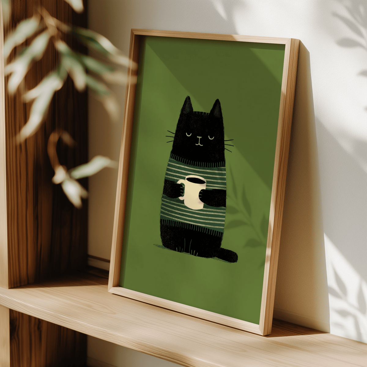 Framed Cat Coffee wall art with a black cat holding a cream coffee cup on green background leaning on wood shelf