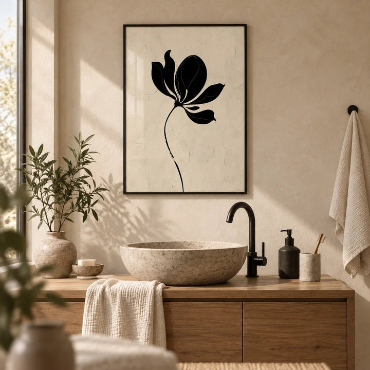 Black Flower Art, framed on the wall of a calm bathroom with warm plaster walls and a stone basin