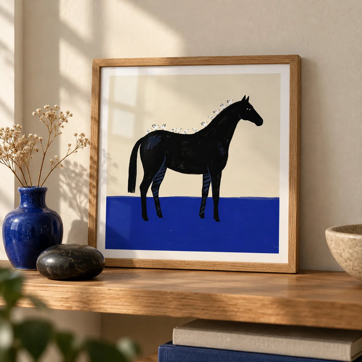 Black Horse Wall Art, a small A4 framed print leaning on an oak shelf in a living room