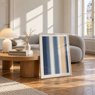 Blue and Cream Wall Art, framed and leaning against a coffee table in a bright living room