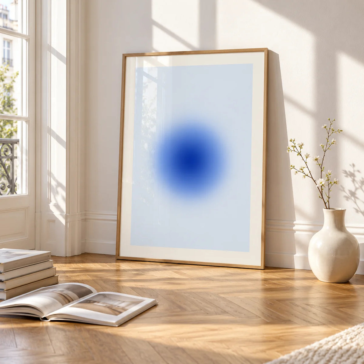 Blue Aura Poster, framed and leaning on the parquet floor of a bright living room