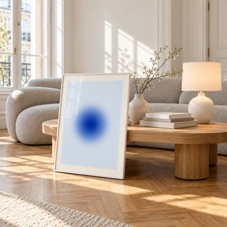 Blue Aura Poster, framed and leaning against a coffee table in a bright living room