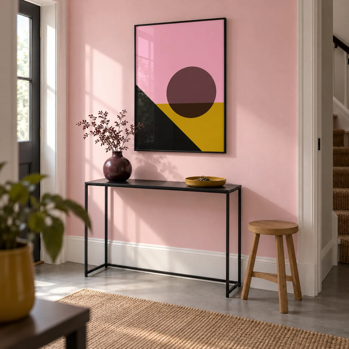 Bright Colored Artwork, framed on the wall of a crisp hallway in a renovated UK terrace with a pale pink wall and plain grey floor