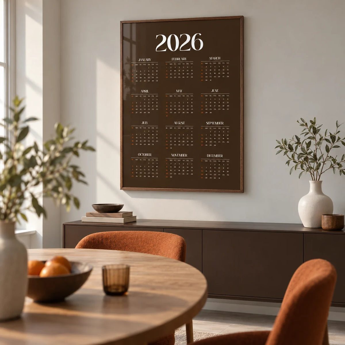 Brown Calendar Print, framed on the wall of a modern dining room in a UK flat with a pale grey wall and a round oak dining table
