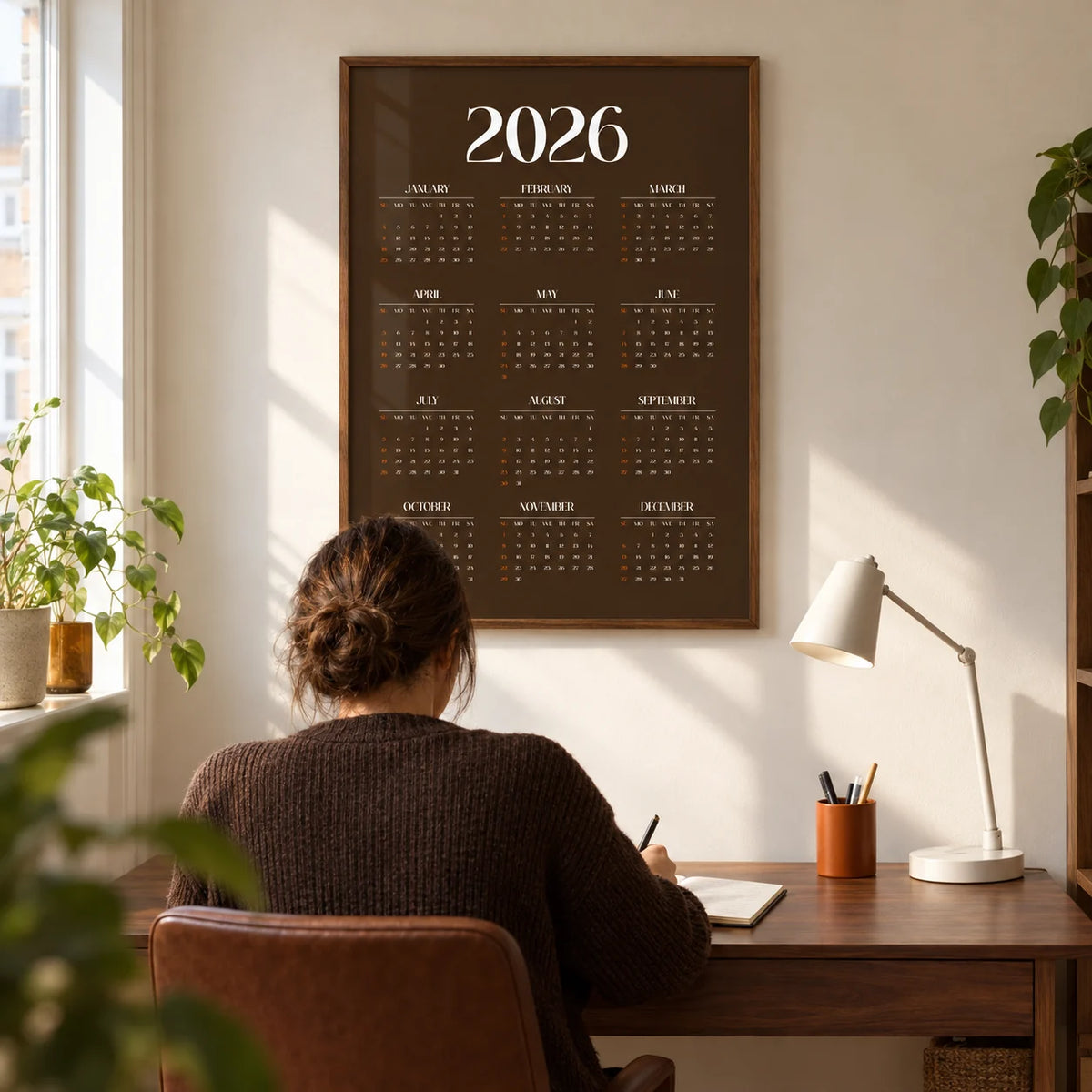 Brown Calendar Print, framed on the wall of a modern home study in a UK terrace with a warm white wall and a walnut desk