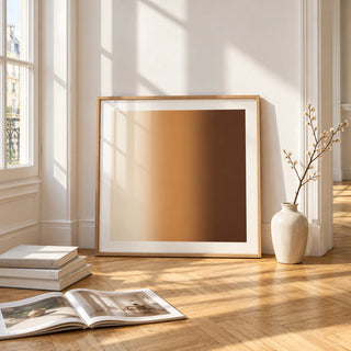 Brown Wall Art, framed and leaning on the parquet floor of a bright living room