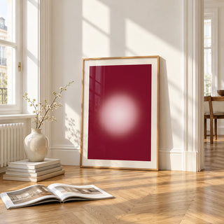 Burgundy Aura Print, framed and leaning on the parquet floor of a bright living room