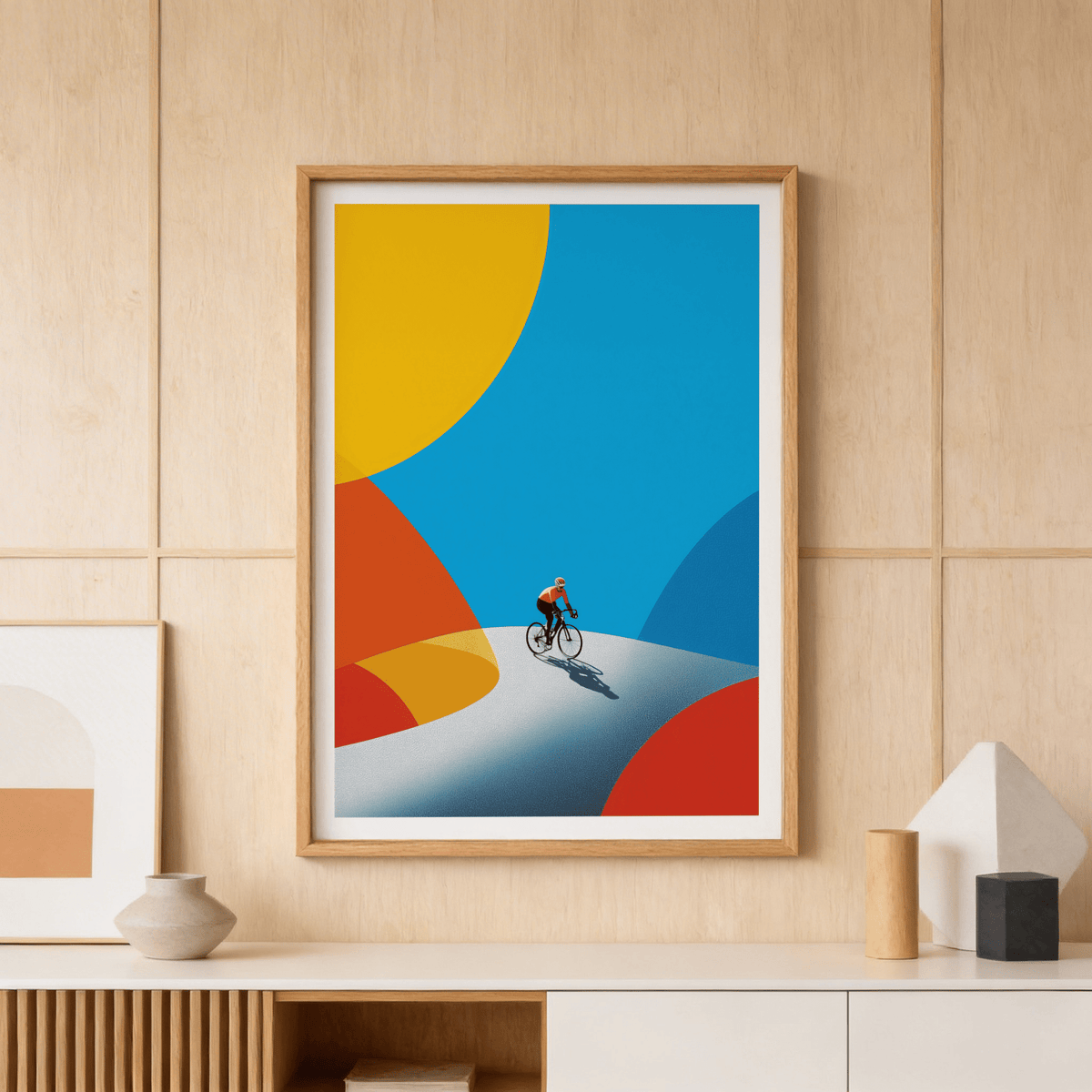 Framed Cycling Art Print of a cyclist on a winding road with minimalist shapes and bright colours on a wood paneled wall