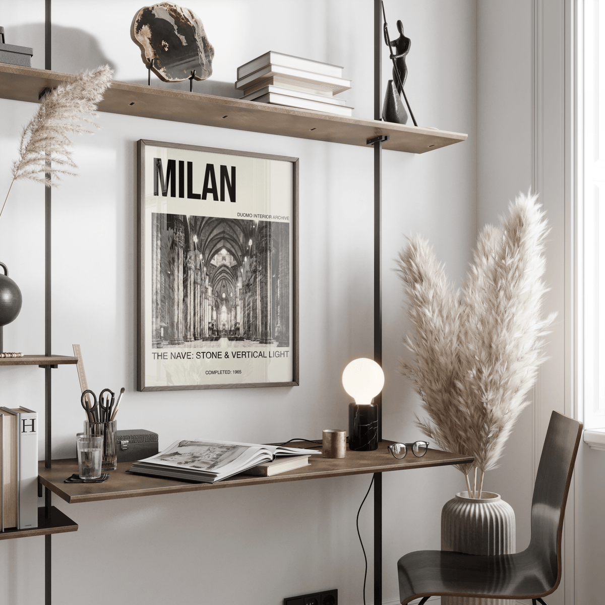 Milan Architecture Art Print framed on a pale wall above a desk with books and pampas grass in a vase