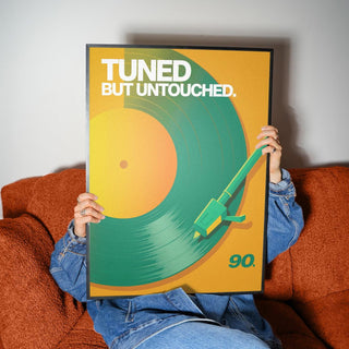 Framed Vinyl Record Art Print with green and orange minimalist record held by person on rust sofa