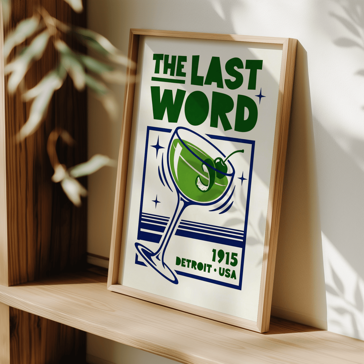 Framed Last Word poster with green and blue illustration leaning on wooden shelf