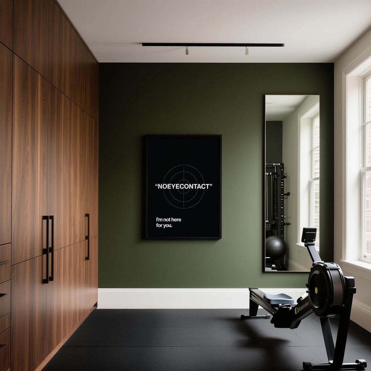 Gym art typographic print No Eye Contact on dark green wall next to a tall mirror and rowing machine