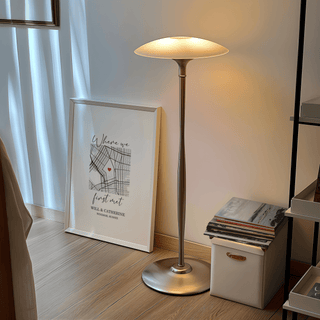 Print leaning on floor lamp base with minimalist map and red heart in neutral setting