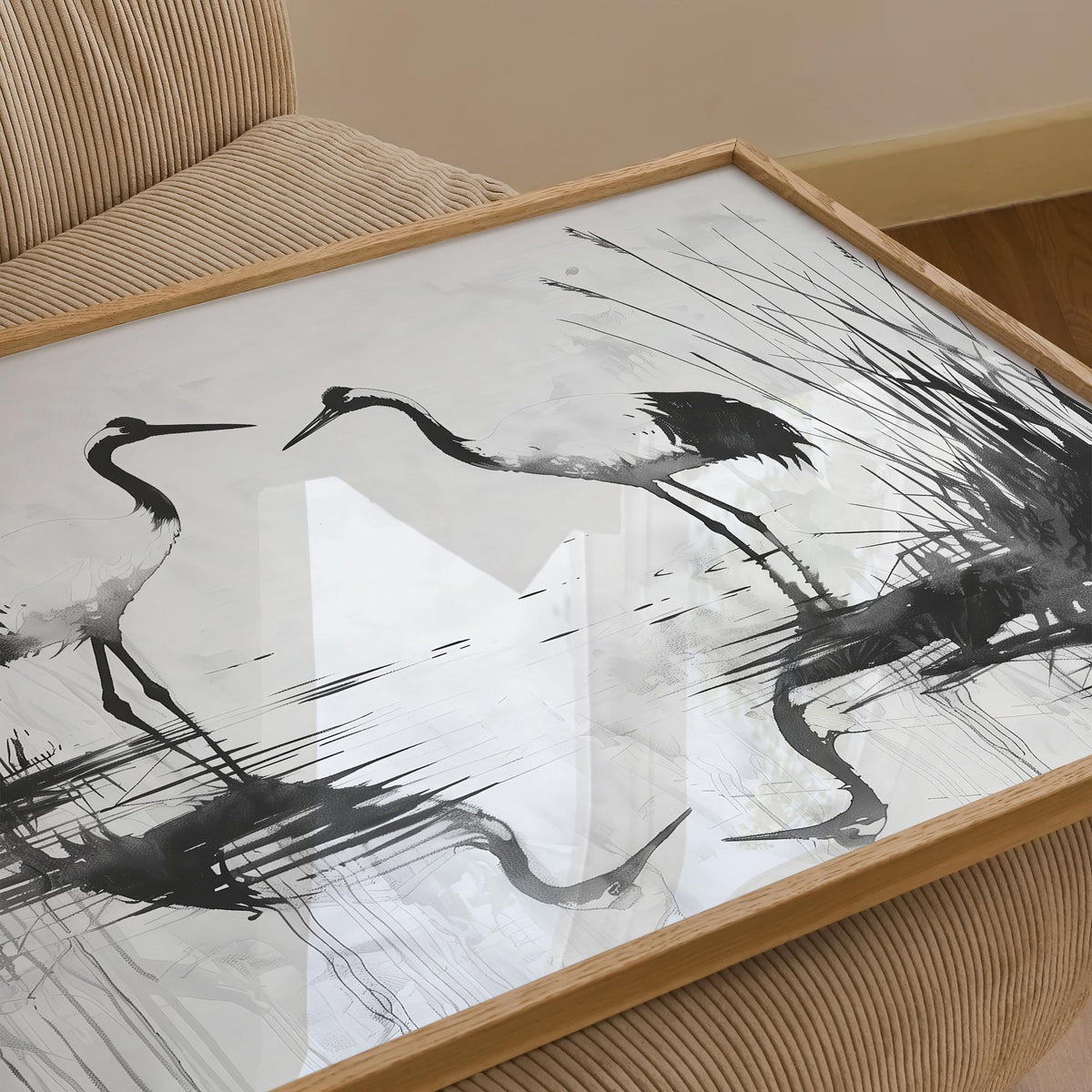 Framed close-up of minimalist bird art with black and grey Japanese ink cranes on a beige chair
