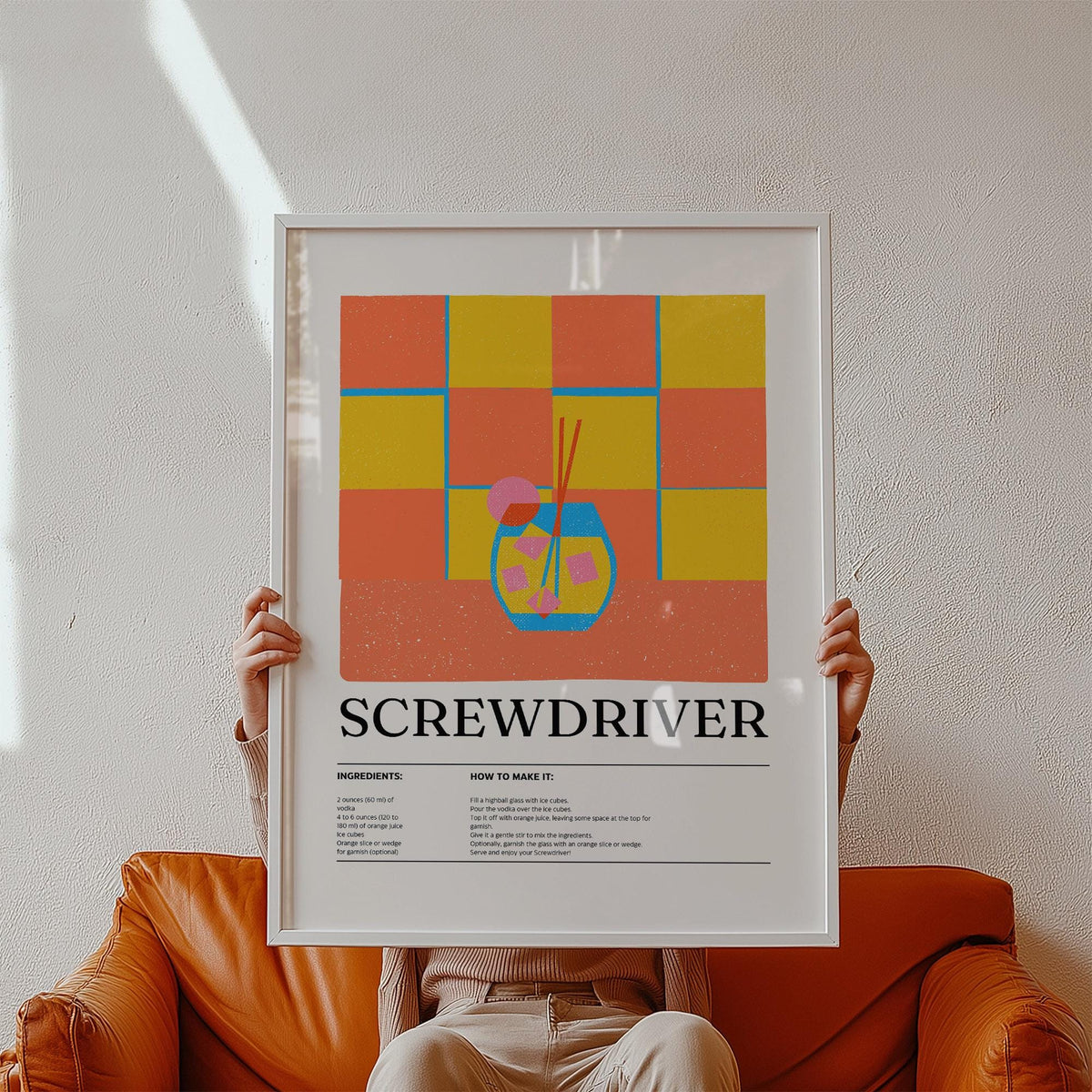 Art Prints Kitchen framed print held on an orange sofa with a colourful minimalist screwdriver cocktail illustration