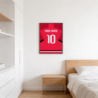Football Shirt Poster in Red with Black Sleeve Stripe and White Number on a white bedroom wall above a wooden bedside table