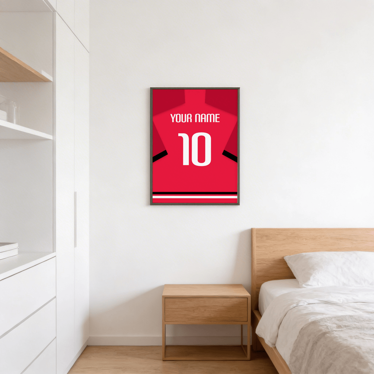 Football Shirt Poster in Red with Black Sleeve Stripe and White Number on a white bedroom wall above a wooden bedside table