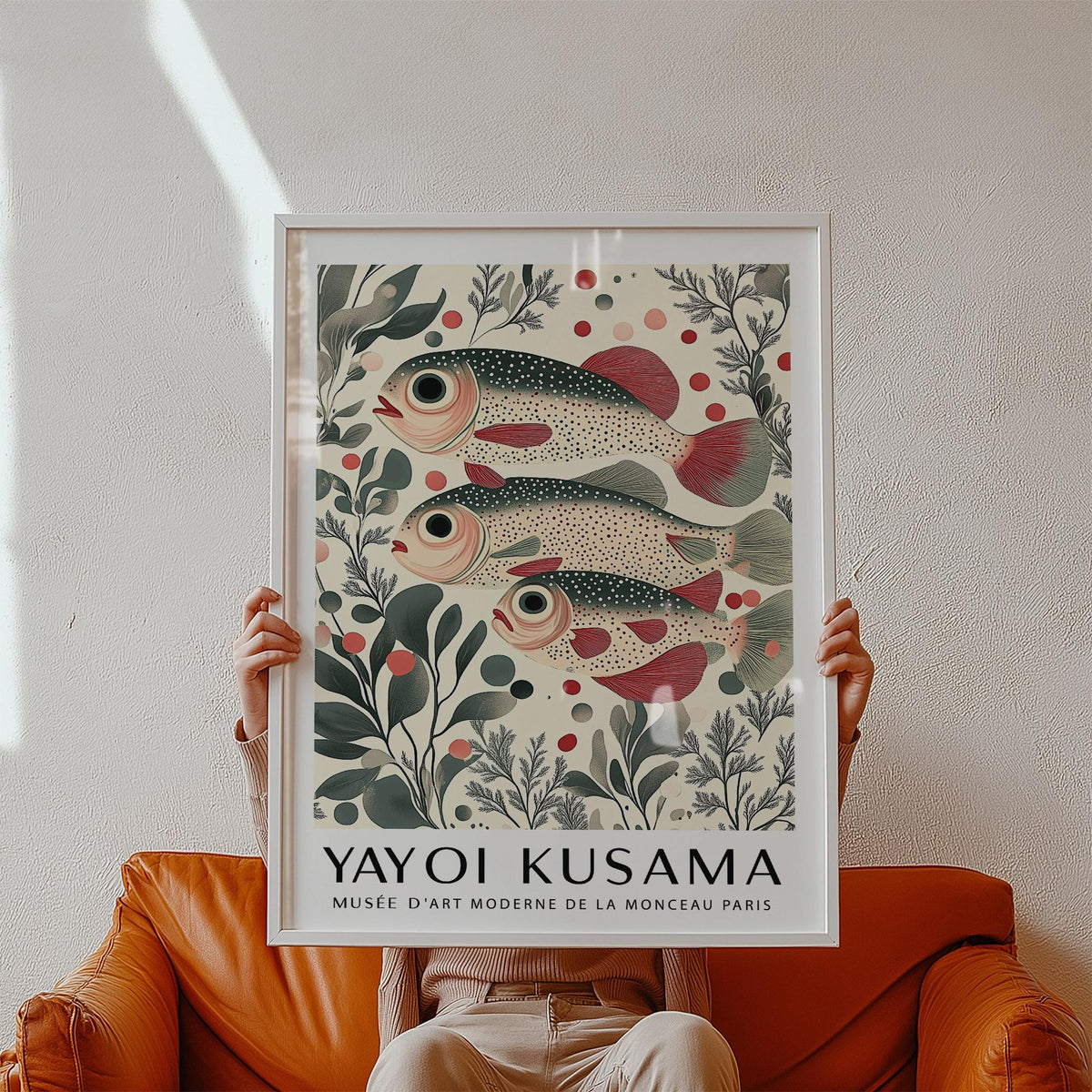 Wall Art of Fish framed print held by person showing redfin fish trio with botanical illustration style