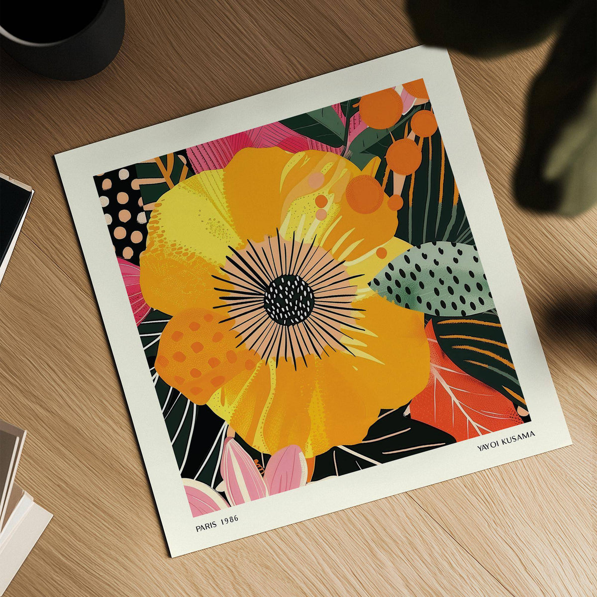 Yellow flower art print with bold colours and dotted leaves laid flat on a wooden surface