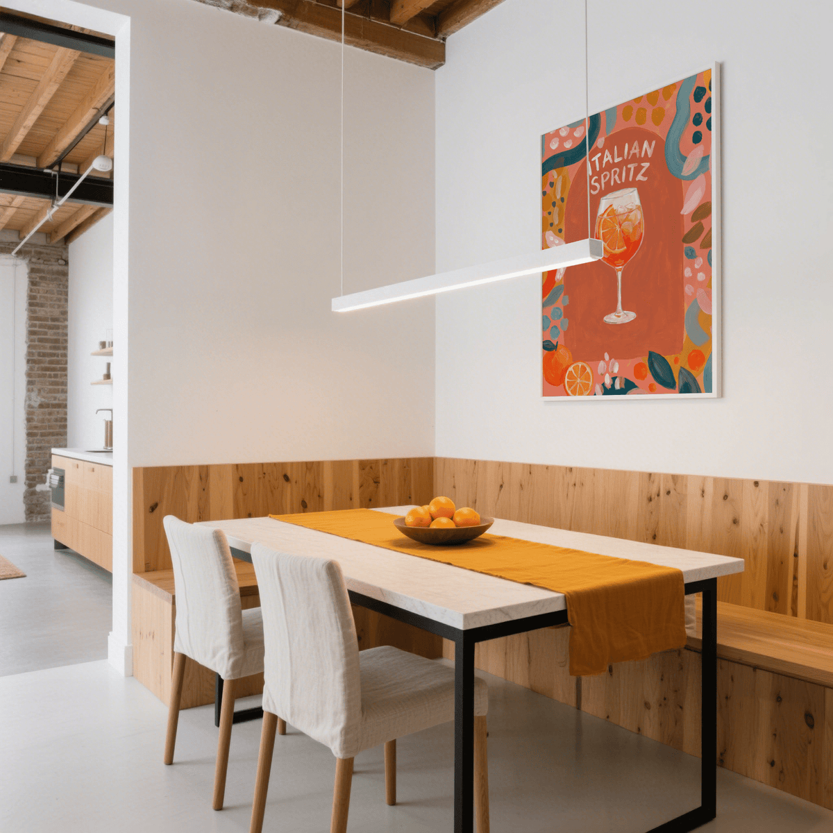 Print on a wall of Italian Spritz Art Print with orange and blue botanical illustration above a wooden dining table with a bowl of fruit